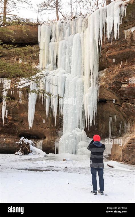 Visitor photographs frozen Lower Falls in winter at Old Man's Cave ...