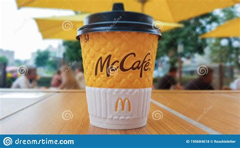 McCafe Menu At McDonalds Restaurant. Yellow Cup Of Coffee On A Table Outdoors With Yellow ...