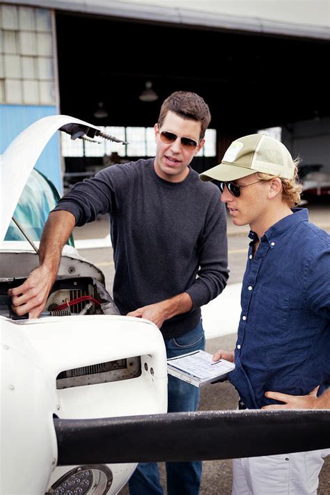 Mechanics Repairing Propeller Airplane While Standing At Field ...