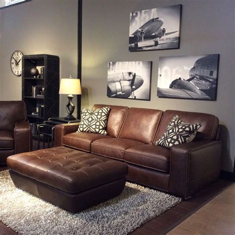 Family room with warm gray walls, black and white art, brown leather furniture, … | Brown ...