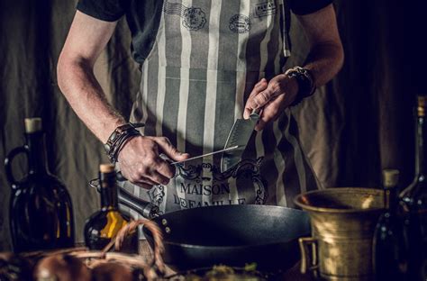 Crop faceless chef sharpening knives before preparing food in frying pan · Free Stock Photo