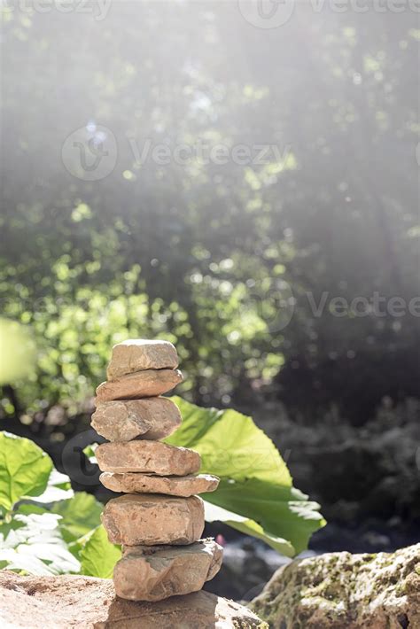 A stack of zen rocks are in the forest with trees in the background ...