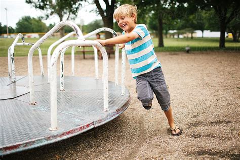 "Child Playing On A Playground Merry-go-round" by Stocksy Contributor "Kelly Knox" - Stocksy