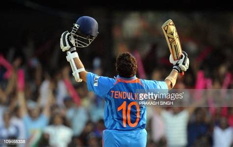 India cricketer Sachin Tendulkar raises his bat to celebrate his ...