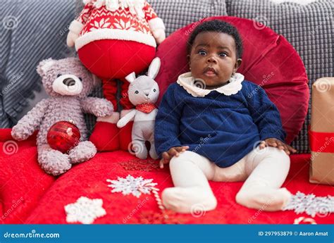 African American Baby Sitting on Sofa by Christmas Gift at Home Stock Image - Image of serious ...