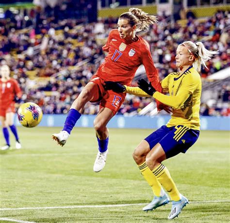 United States forward Tobin Heath #17 (left) passes the ball in midair in front of Sweden ...