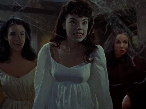 two women in white dresses standing next to each other with spider web ...