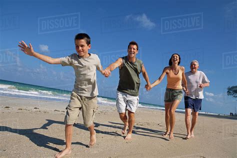 Caucasian family holding hands on beach - Stock Photo - Dissolve