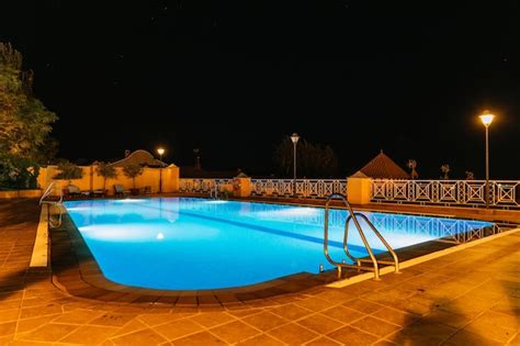 Premium Photo | Large hotel swimming pool illuminated at night with ...