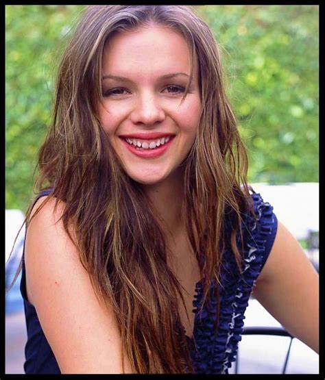 a woman with long hair smiling at the camera