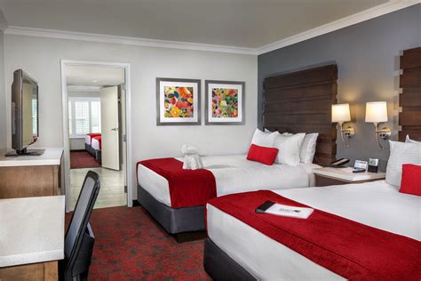 two beds in a hotel room with red and white bedding