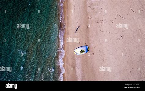 Vertical aerial view shot of a man walking with a twin tip board and a ...