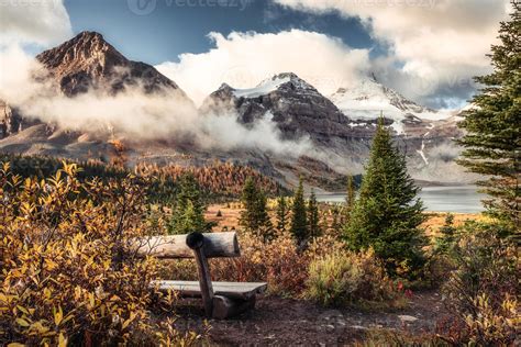 Mount Assiniboine on Lake Magog and wooden chair in autumn forest at ...