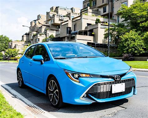 2021 Toyota Corolla Hatchback XSE in Blue Flame L parked on the side of the road with apartment ...