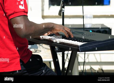 Synthesizer keyboard player at a live concert, playing a chord on piano ...