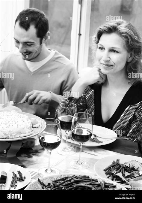 Couple eating at dining room table Stock Photo - Alamy