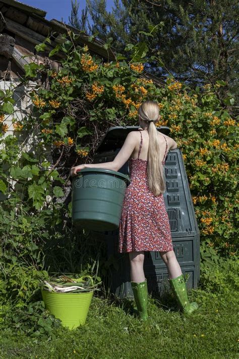 A Young Girl Puts Vegetable Waste into a Compost Bin in the Garden Stock Image - Image of ...