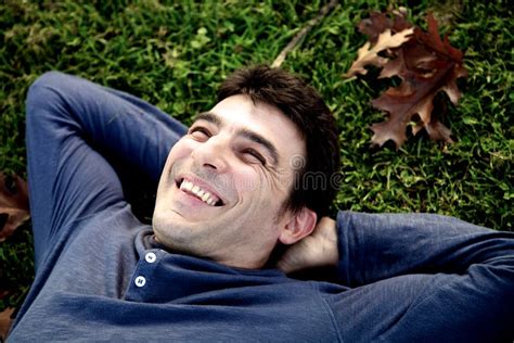 Relaxed Man Laughing In Park Laying On The Grass Royalty Free Stock Photography - Image: 33013087