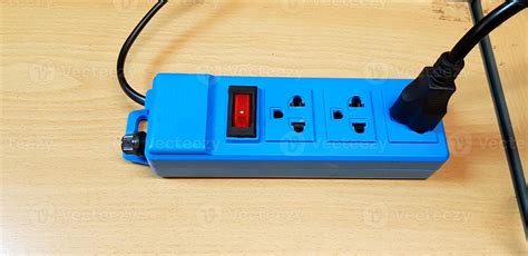 Blue AC outlet with red button or switch on or off and black power cord cable connect putting on ...