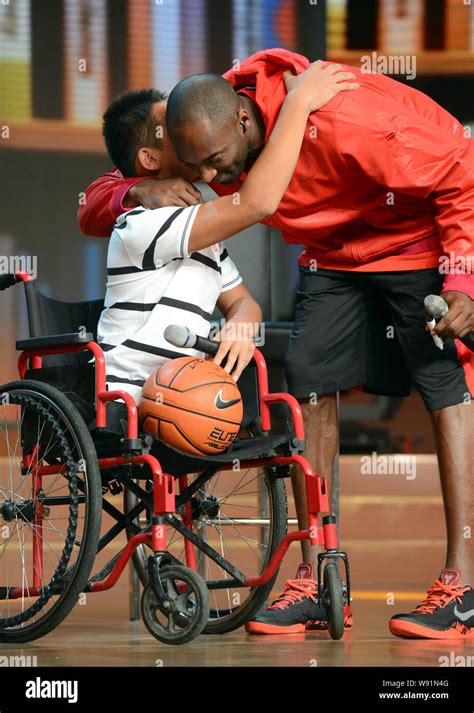 NBA star Kobe Bryant, right, hugs a young handicapped fan during a CCTV program on his China ...