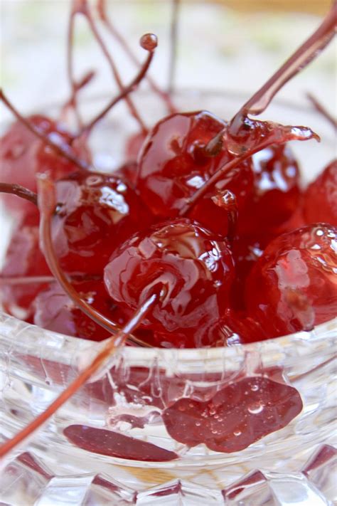 some cherries in a glass bowl on a table