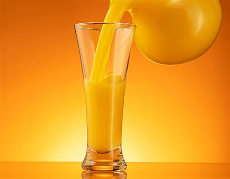 Premium Photo | Orange juice pouring into glass with splash