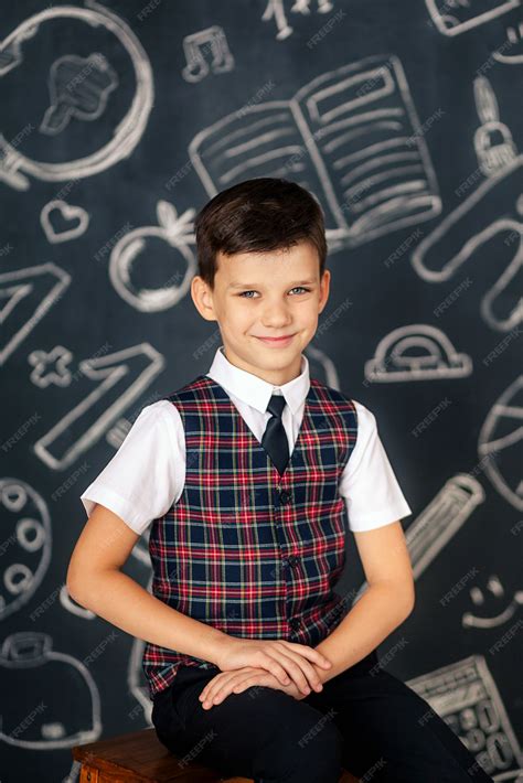 Premium Photo | Portrait of a happy cute schoolboy on black chalkboard ...