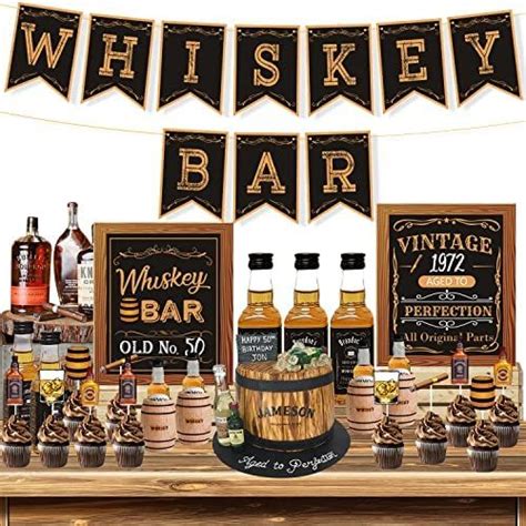 a table topped with bottles of whiskey and cupcakes next to a sign that says whiskey bar