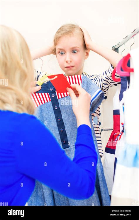 Little girl in shock looking at the price label in clothing store Stock Photo - Alamy