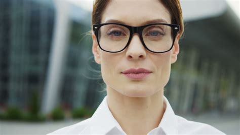 Free stock video - Close up of the charming woman in glasses looking straight into the camera on ...