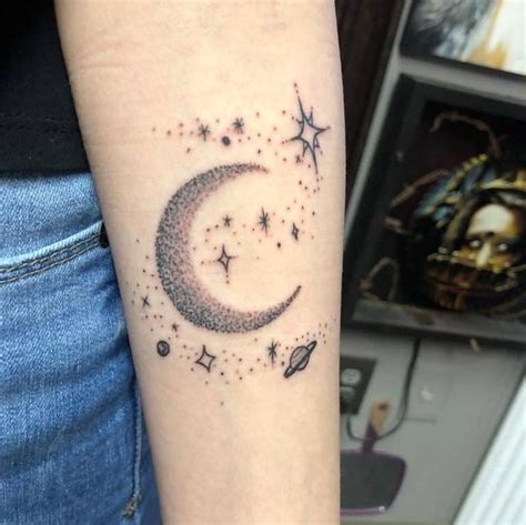 a woman's arm with a small crescent and stars tattoo on it