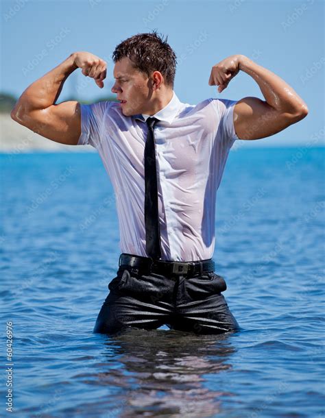 Muscular young sexy guy standing in the sea in business suit Stock Photo | Adobe Stock