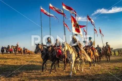 Polish Hussars riding on horses and carrying emblems and flags ...