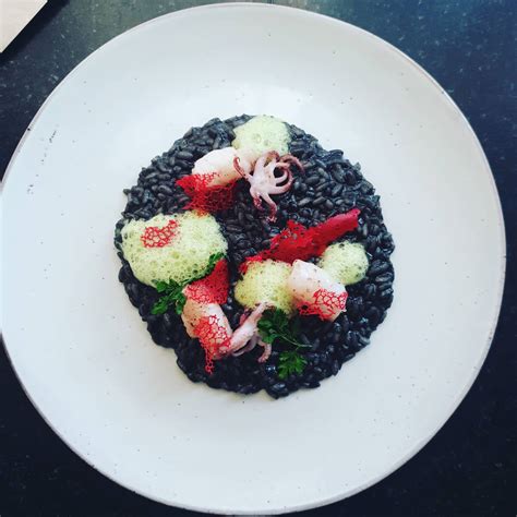 Baby squid & squid ink risotto- coral tuile- pea & parsley foam.