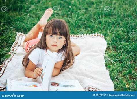 Little Beautiful Girl Lie on Grass with Book Looking at Camera Stock ...