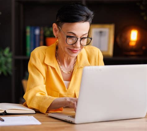 A Mature Businesswoman Using Laptop in Home Office Stock Photo - Image of browsing, internet ...