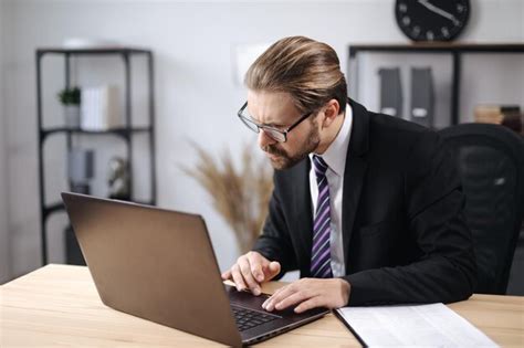 Premium Photo | Man in suit working on laptop at office