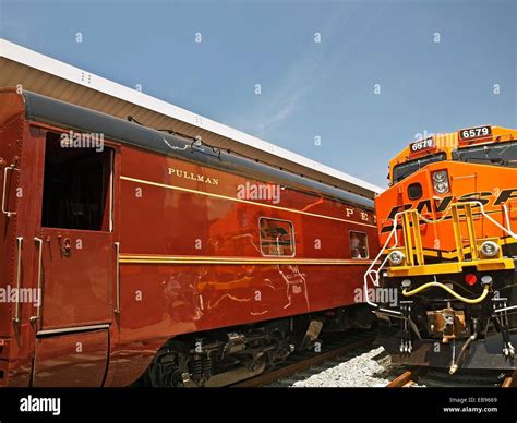 An old Pullman sleeper car sits along side a modern locomotive on ...