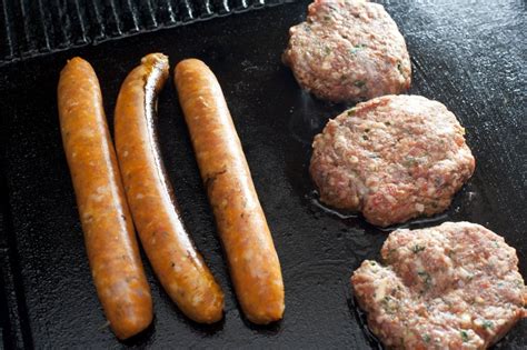 Beef patties and sausages on a barbecue - Free Stock Image