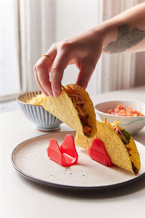 a plate with a taco on it being held up by someone's hand