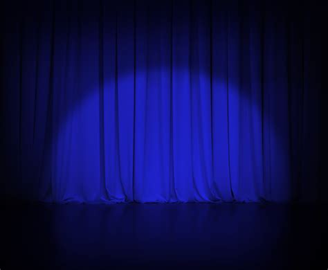 theatre dark blue curtain or drapes background with light spot - Tim Vine