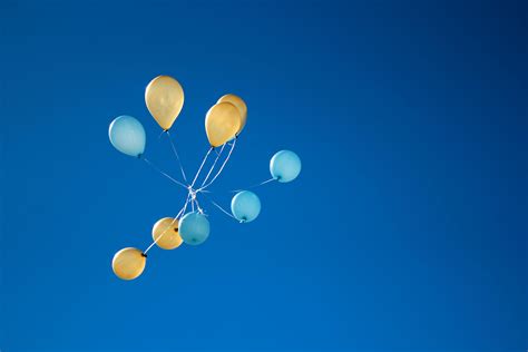 Photo of Yellow And Blue Balloons On Sky · Free Stock Photo