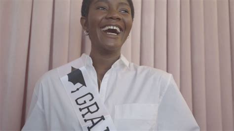 Black woman poses on her graduation day during the graduation ceremony ...