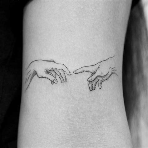 Hands from 'The Creation of Adam" tattooed on the