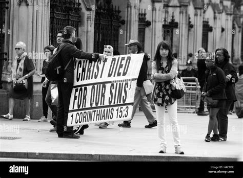 A street preacher preaching to people walking passed The Houses of Parliament in Westminster ...