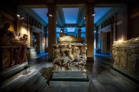 some statues are on display in a room with blue light from the ceiling ...