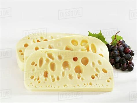 Three slices of Leerdammer cheese with grapes - Stock Photo - Dissolve