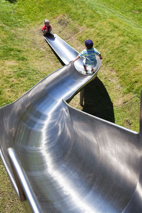 A bespoke stainless steel curved slide at Draper's Field. Constructed ...