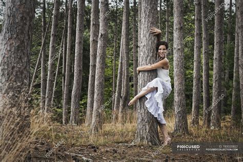 Woman hugging tree while dance and looking in camera in forest. — tree ...