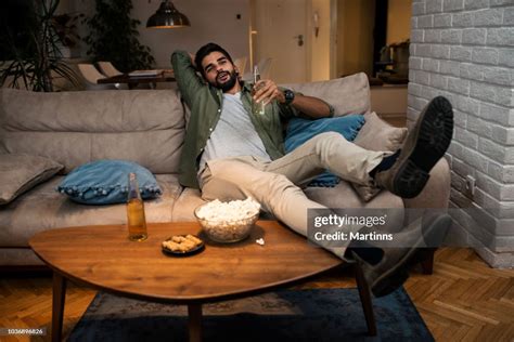 Young Man Lying On Couch Watching Tv High-Res Stock Photo - Getty Images